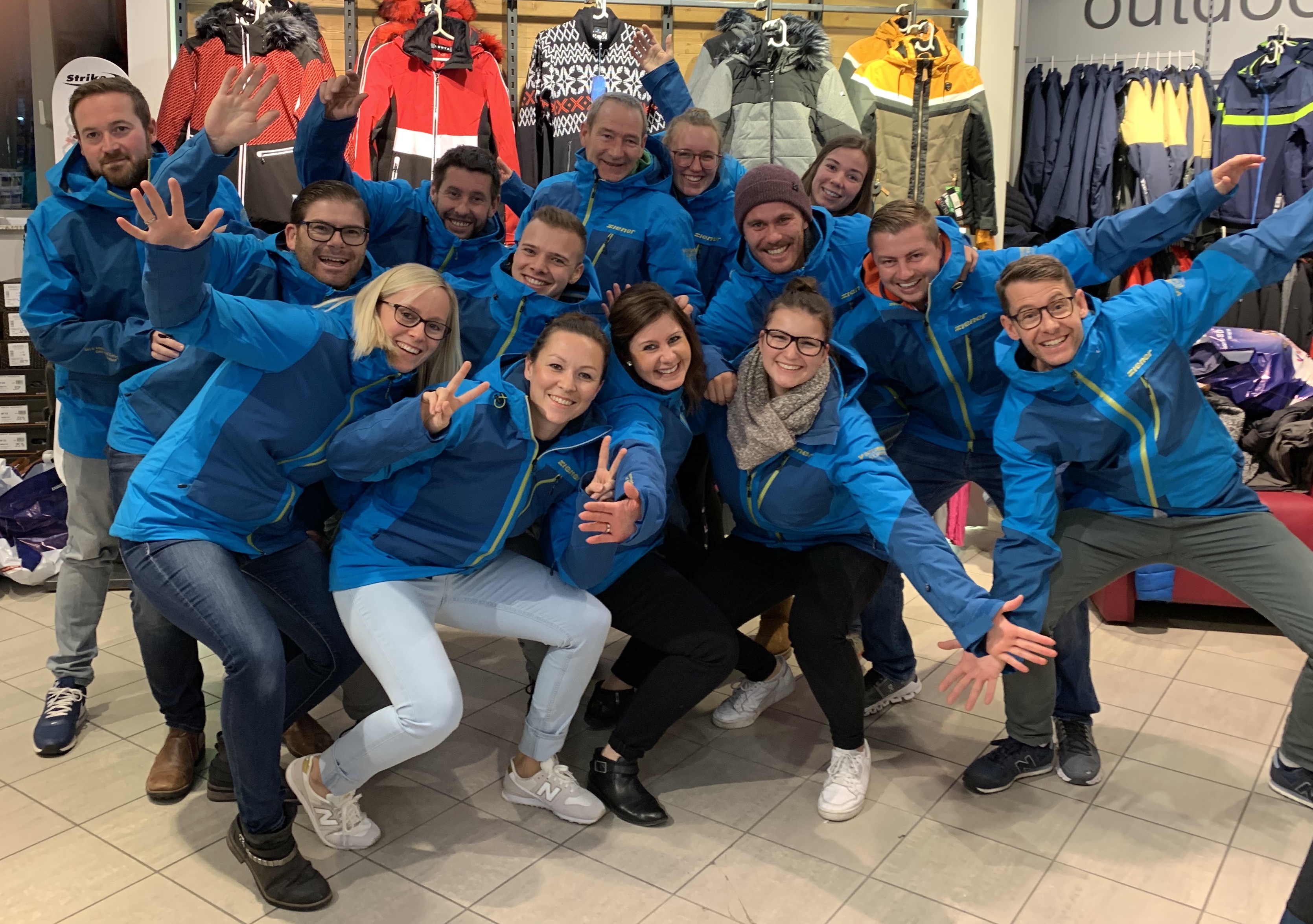 jubelnde Ski- und Snowboardlehrer im Outdoorladen und neuen Skijacken