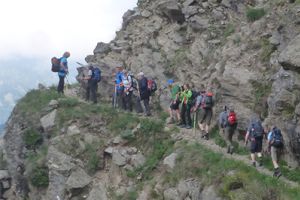 Wandergruppe auf schmalem Pfad an einer Felswand